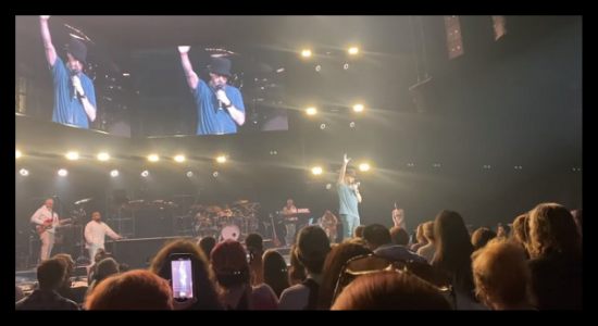 TobyMac performs for a crowd with his hands up in praise