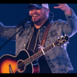Micah Tyler lifts his hands to the Lord during a live performance