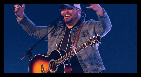 Micah Tyler lifts his hands to the Lord during a live performance